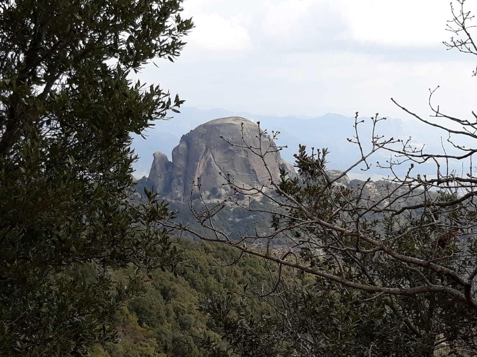 A mountainous landscape with a prominent rock formation in the background.