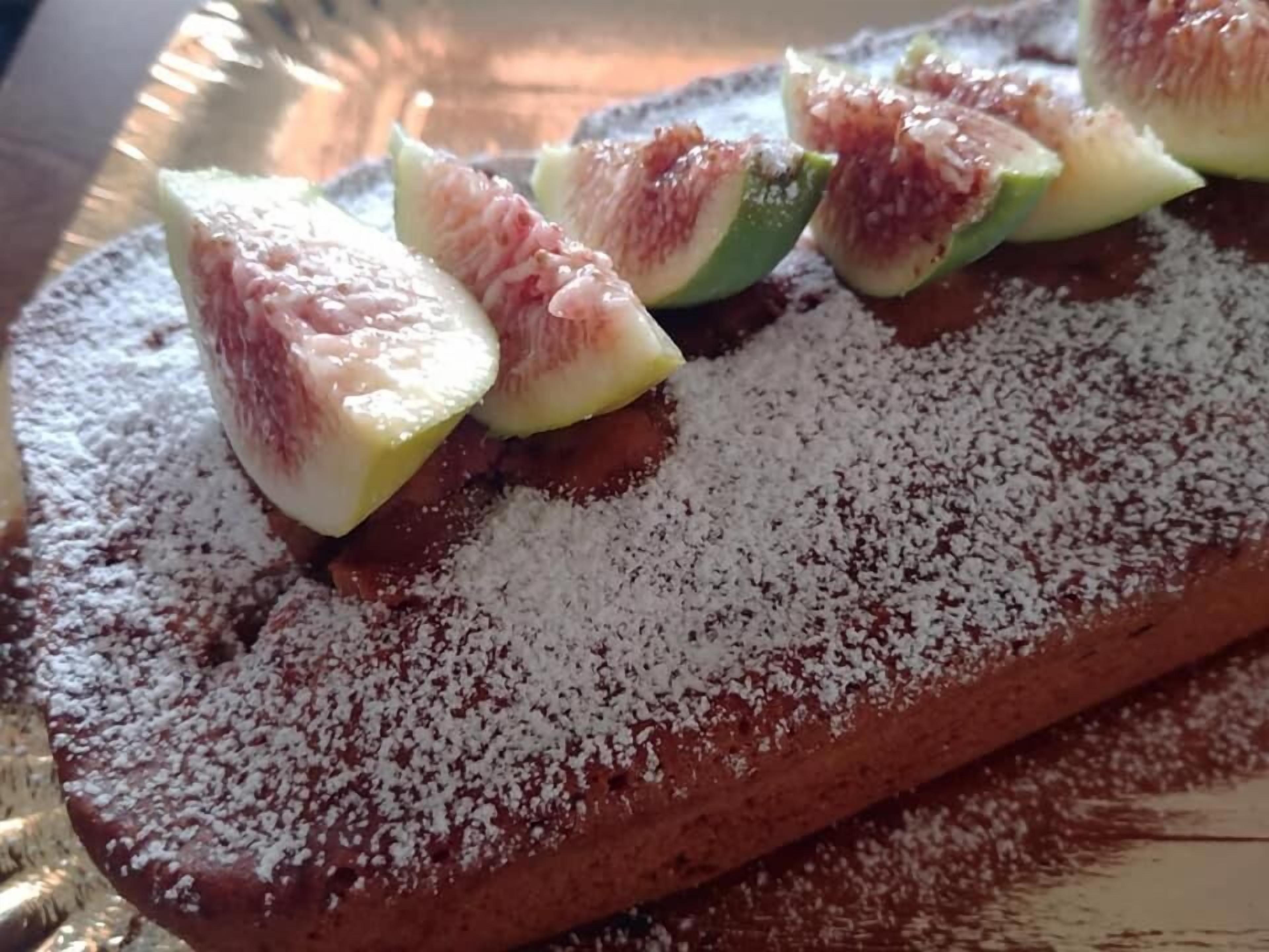 Un postre con higos laminados y azúcar glas.