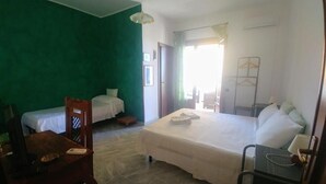 Une chambre d’hôtel avec un grand lit, un lit plus petit, un bureau et une chaise.