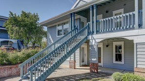Une maison à deux étages avec un escalier bleu menant à un balcon.