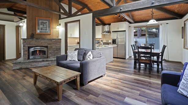 A spacious living area with a fireplace, wooden flooring, and a dining area with a table and chairs. - 3 Killdeer Lane Pet Friendly Home 3 Minutes Walk from SHARC by RedAwning (Bend)