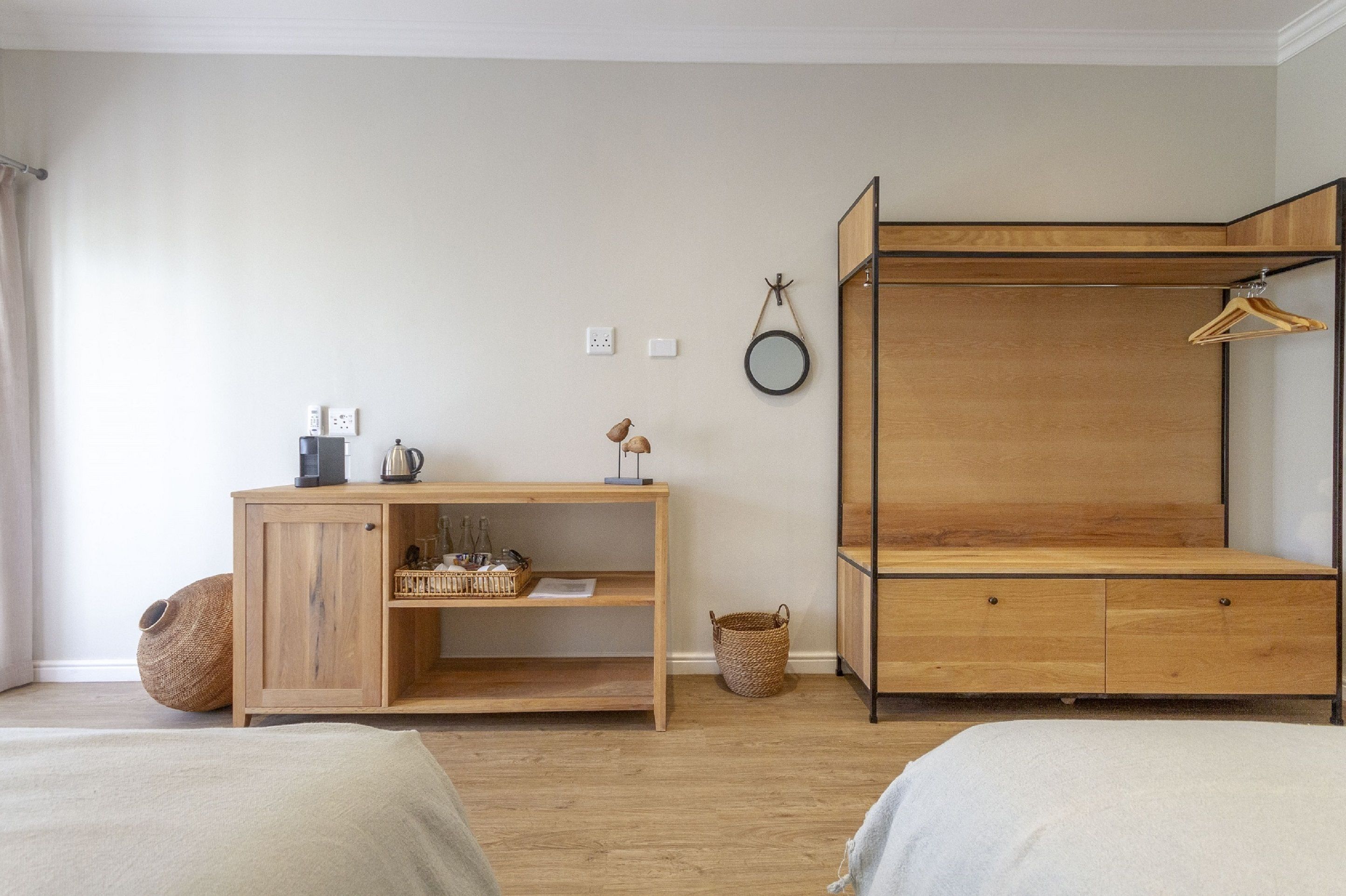Une chambre avec un lit superposé en bois, une table de chevet en bois avec une lampe et un petit bureau en bois.