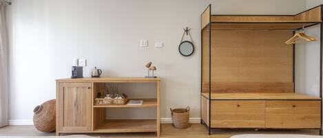 Une chambre avec un lit superposé en bois, une table de chevet en bois avec une lampe et un petit bureau en bois.