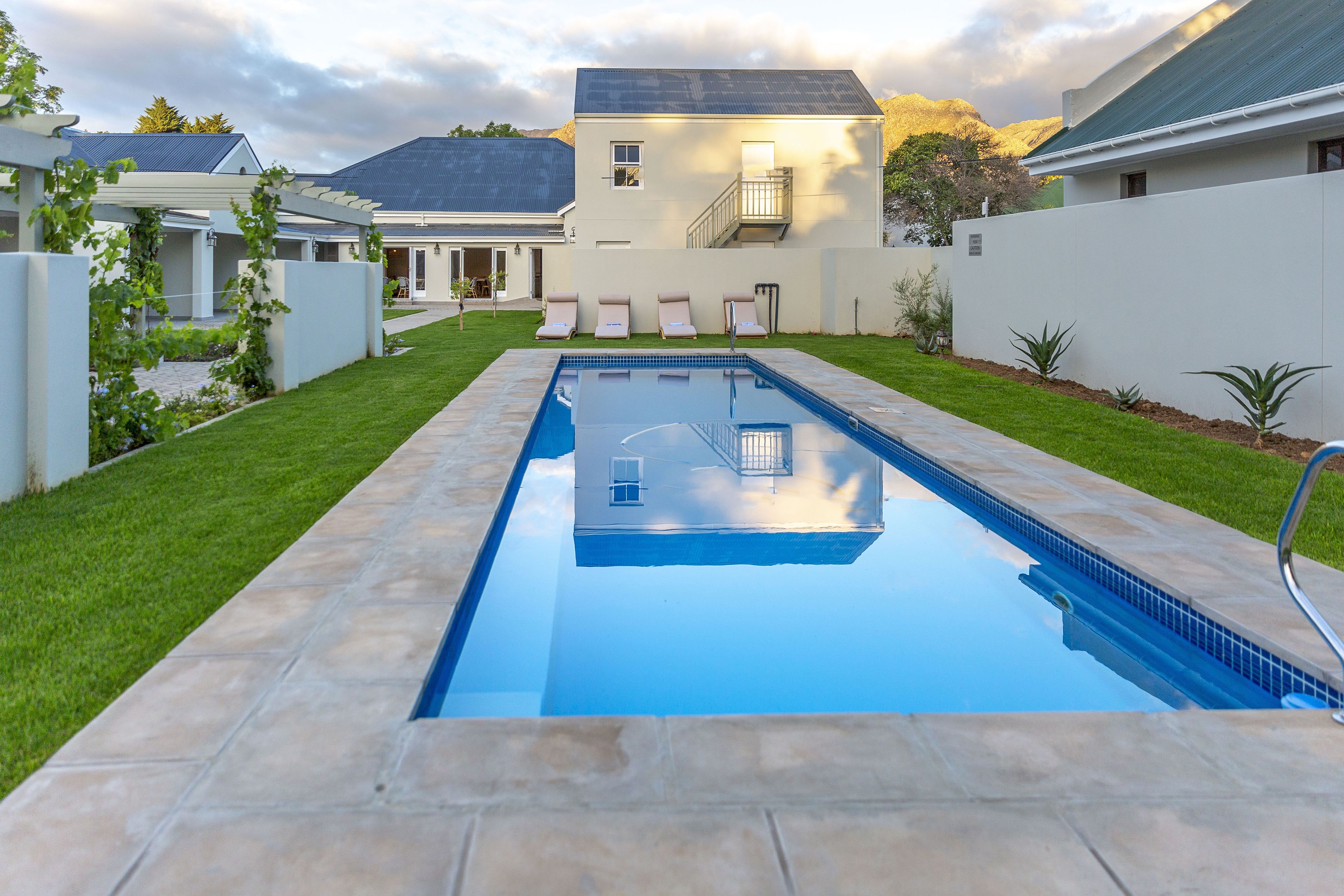 A rectangular swimming pool with a clear blue water surface, surrounded by a paved deck.