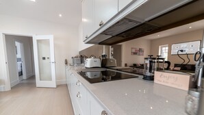 Una cocina moderna con una isla central, electrodomésticos integrados y un letrero que dice "Enjoy the life -things".