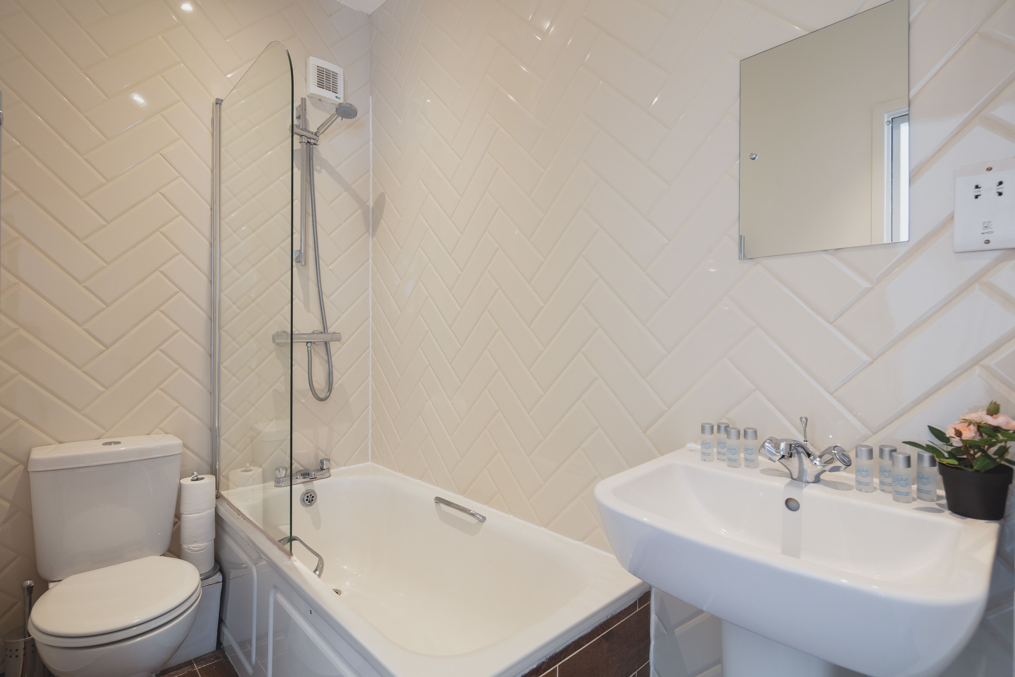 A bathroom with a shower, toilet, bathtub, and sink.