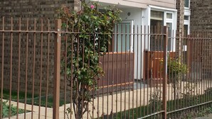 A two-story residential building with a brick facade, a metal fence, and a small tree in front. - Stunning Apartment In London Tottenham (London)