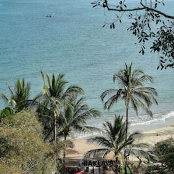On the beach, black sand, sun-loungers, beach umbrellas
