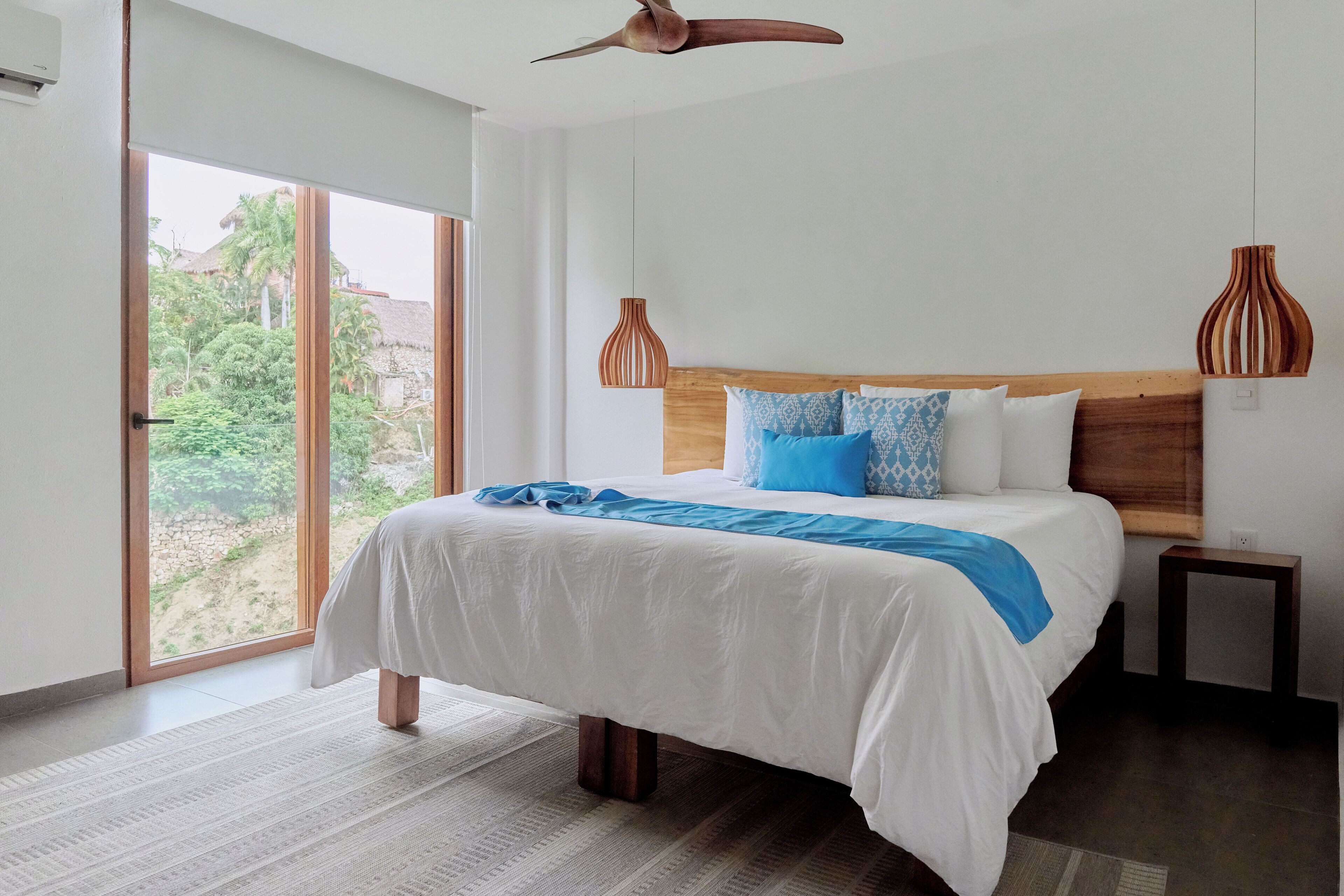 Un dormitorio con una cama grande, cabecero de madera y dos lámparas de pared.