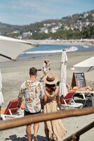 On the beach, black sand, sun loungers, beach umbrellas
