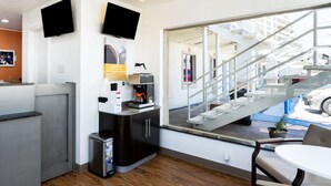 A modern hotel room with a kitchenette, a large window with a view of the outside, and a small seating area. - Motel 6 Odessa, TX - 2nd Street (Odessa)