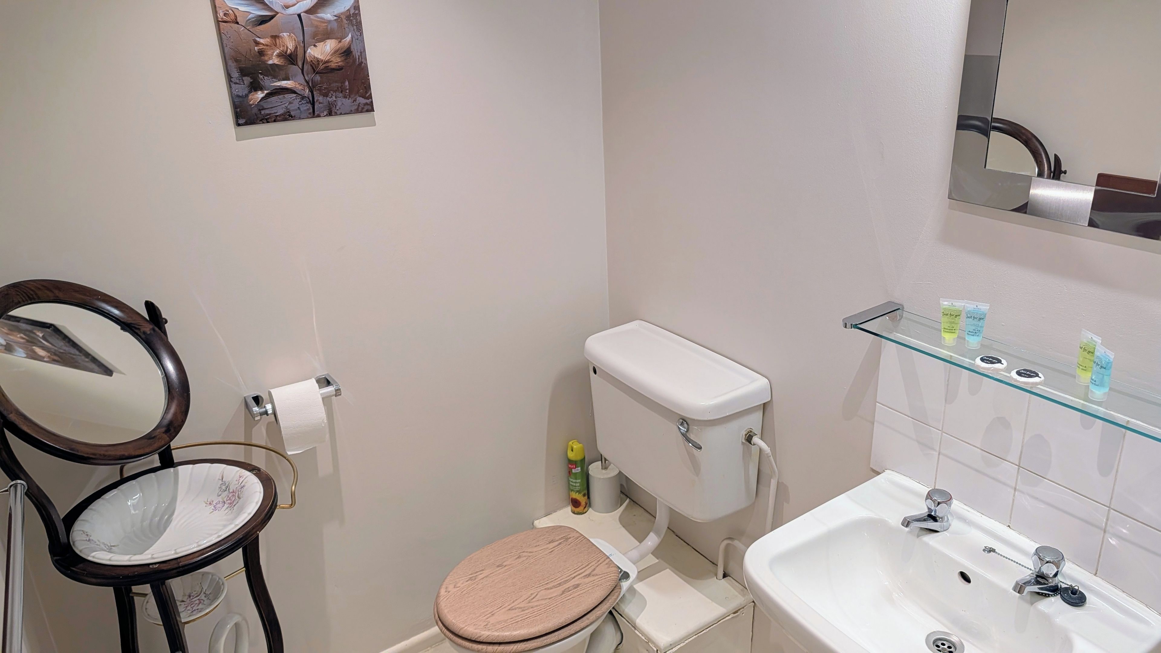 Ein Badezimmer mit Toilette, Waschbecken und Spiegel.