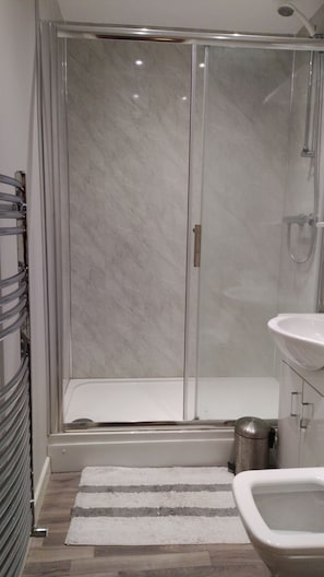 Quarto solteiro básico | Banheiro | Chuveiro, toalhas de banho
