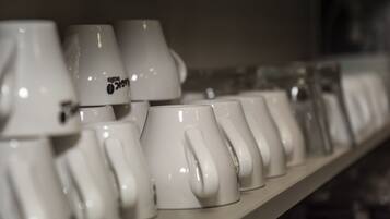 A row of white ceramic mugs on a shelf.