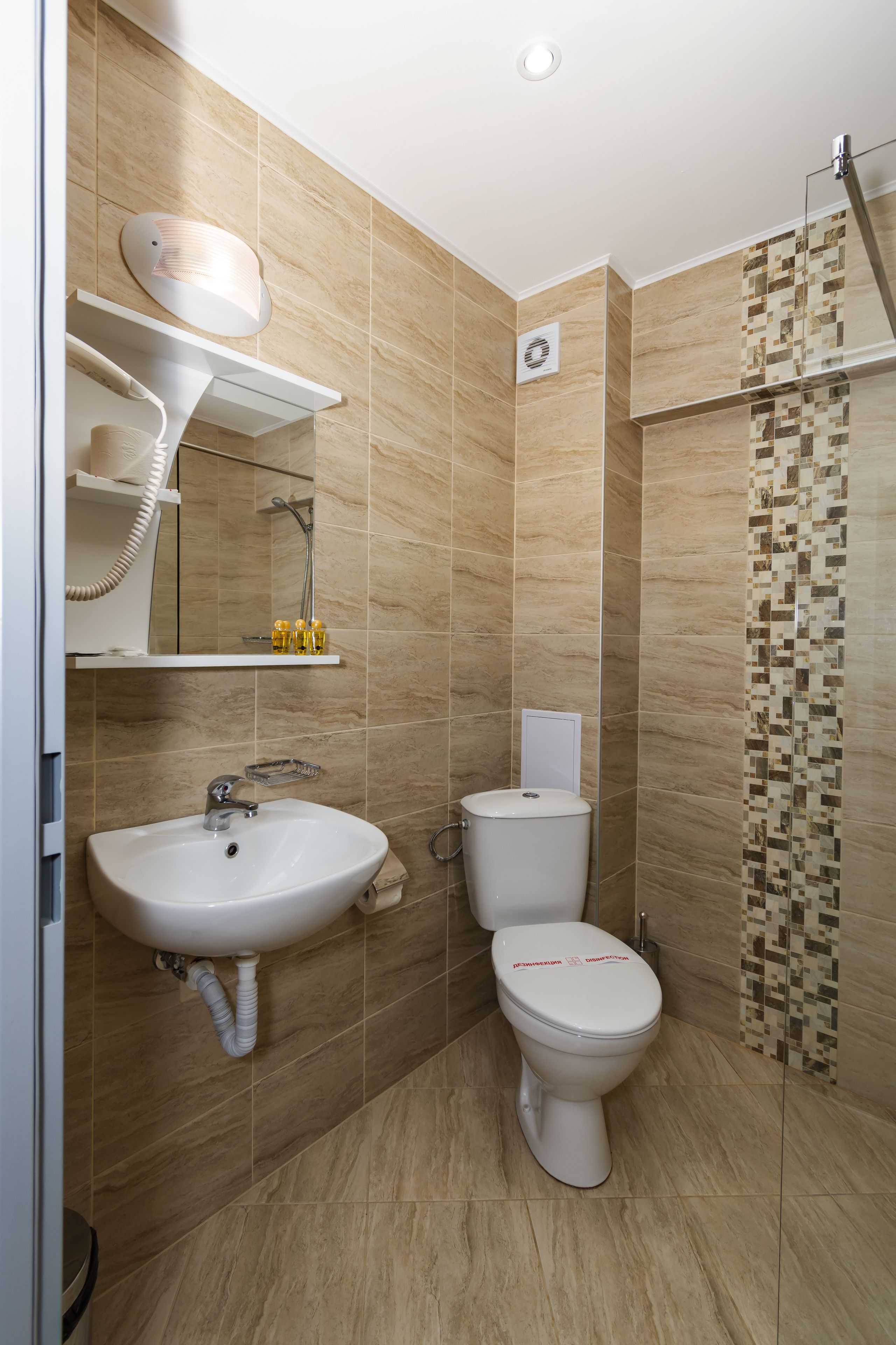 A modern bathroom with a sink, toilet, and shower. There are shelves with toiletries and a towel rack.
