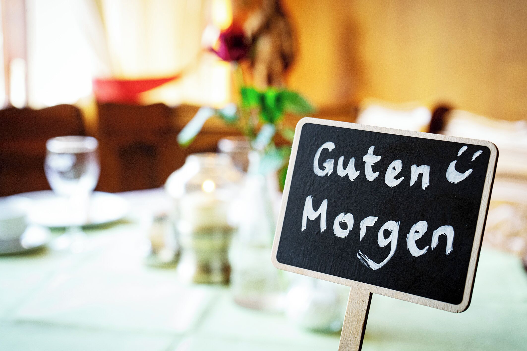 En skylt med texten ”Guten Morgen” i en restaurangmiljö.