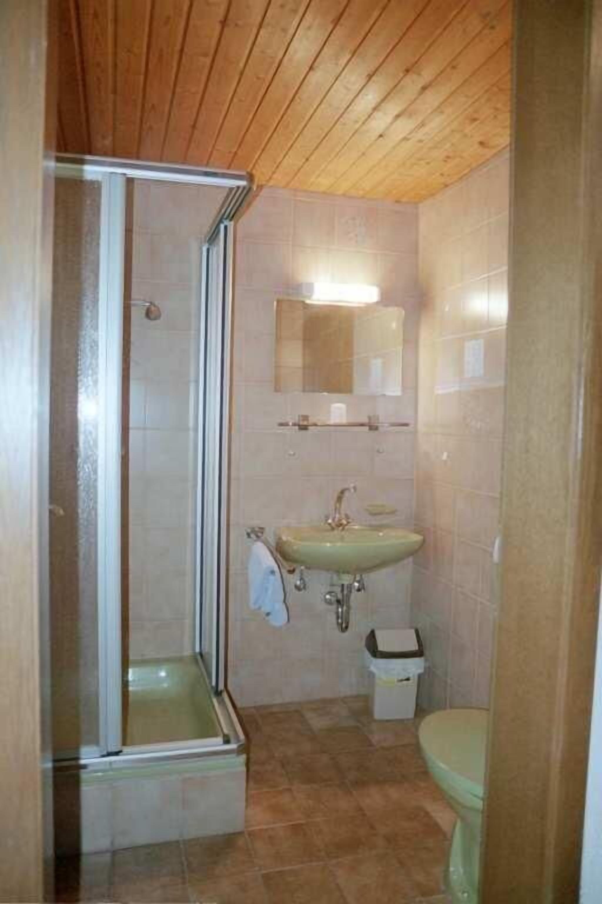 Une salle de bain avec une douche, un lavabo et des toilettes.