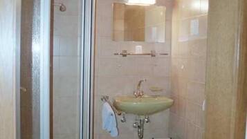 Une salle de bain avec une douche, un lavabo et des toilettes.