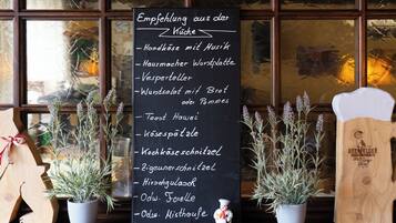 Un tablero de menú con una lista de platos en un restaurante.