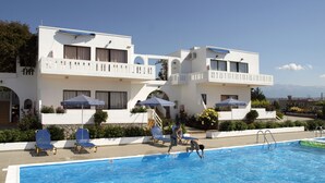 A hotel with a swimming pool, sun loungers, and umbrellas. - Michalis Villas (Chania)