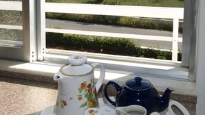 A tray with a teapot, cups, and a sugar bowl on a balcony overlooking a scenic landscape. - Michalis Villas (Chania)
