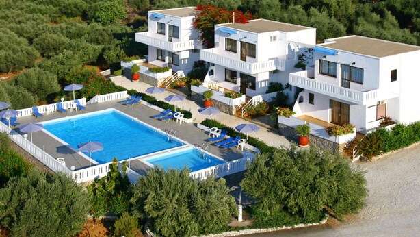A modern hotel with a swimming pool, multiple balconies, and a lush surrounding landscape. - Michalis Villas (Chania)