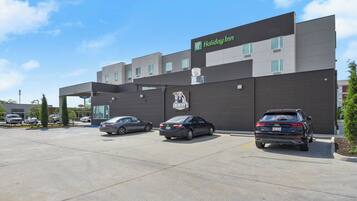 A Holiday Inn Express hotel with a parking lot and three cars parked in front.