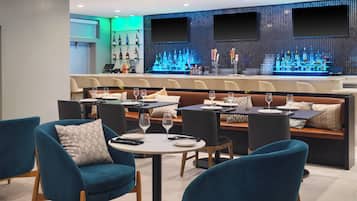 Un área de bar moderna con asientos y mostrador.