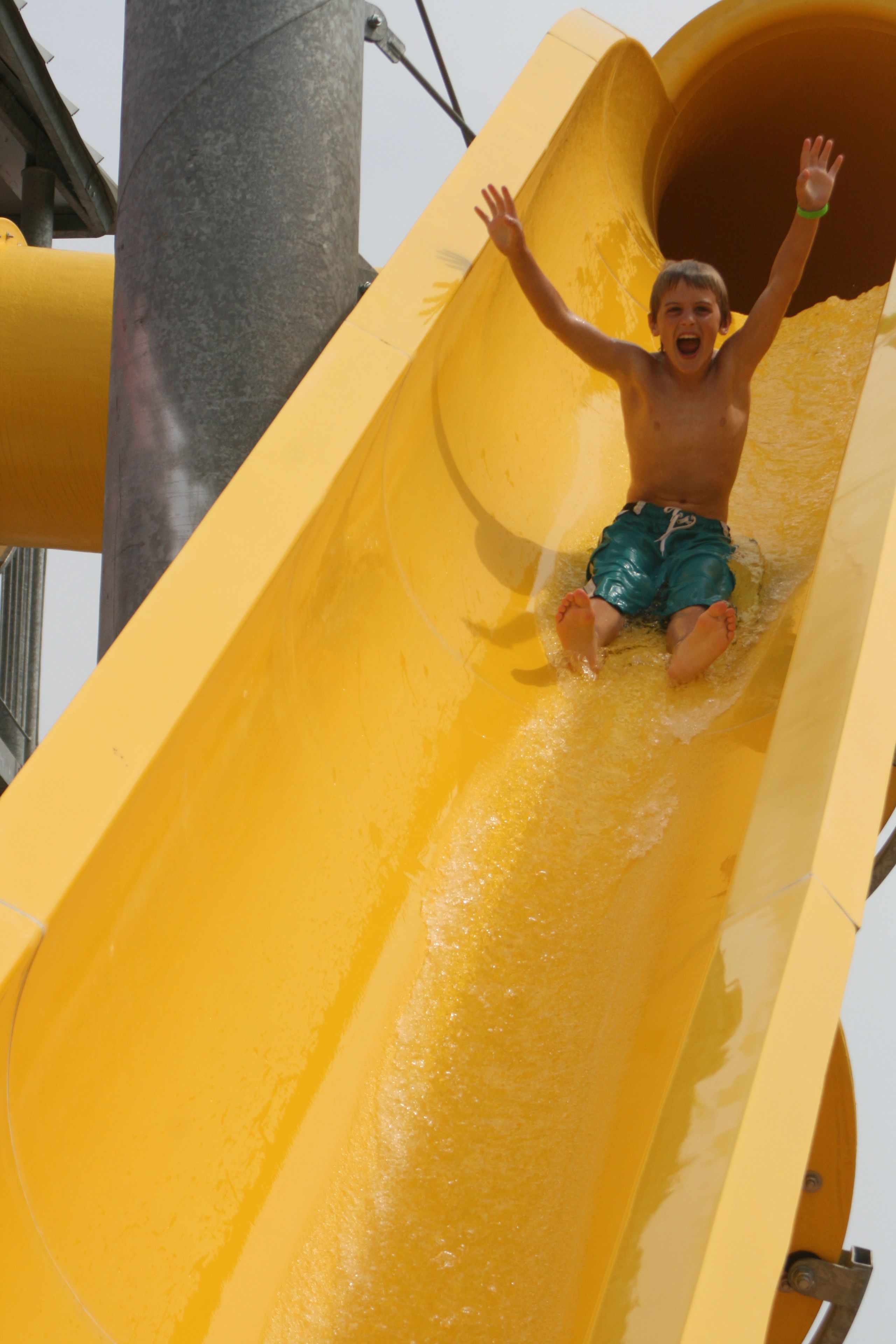 A person sliding down a yellow water slide.
