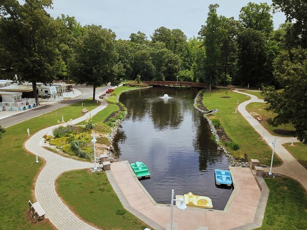 Ein Park mit Teich, Spazierwegen und Booten.