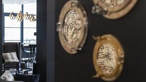 A modern interior with a seating area featuring a sofa and chairs, a dining table, and decorative wall art. - HARBR. Hotel Heilbronn, a member of Radisson Individuals (Heilbronn)