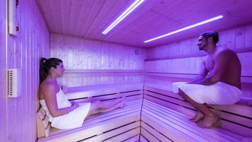 Una sauna con bancos de madera y techo iluminado en morado.