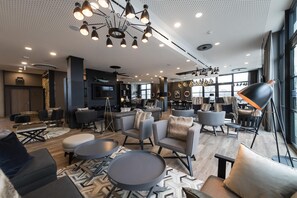 Ein modernes Interieur mit einer Sitzecke, einem Essbereich und einem großen Fenster, das für natürliches Licht sorgt.
