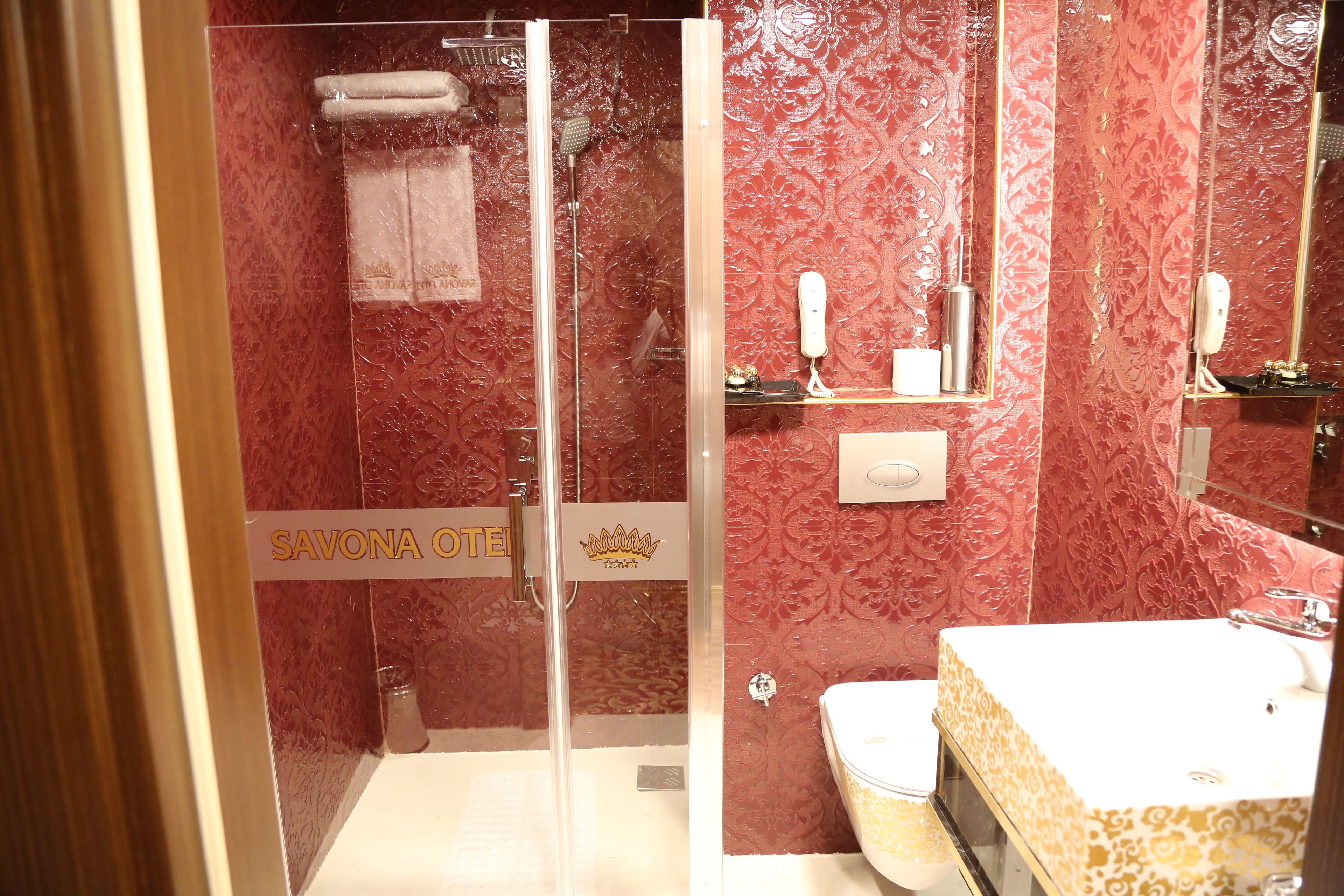 A bathroom with a shower, toilet, and sink.