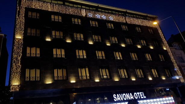 Un edificio de varios pisos, con un letrero que indica 'Savona Hotel' a nivel de la calle.