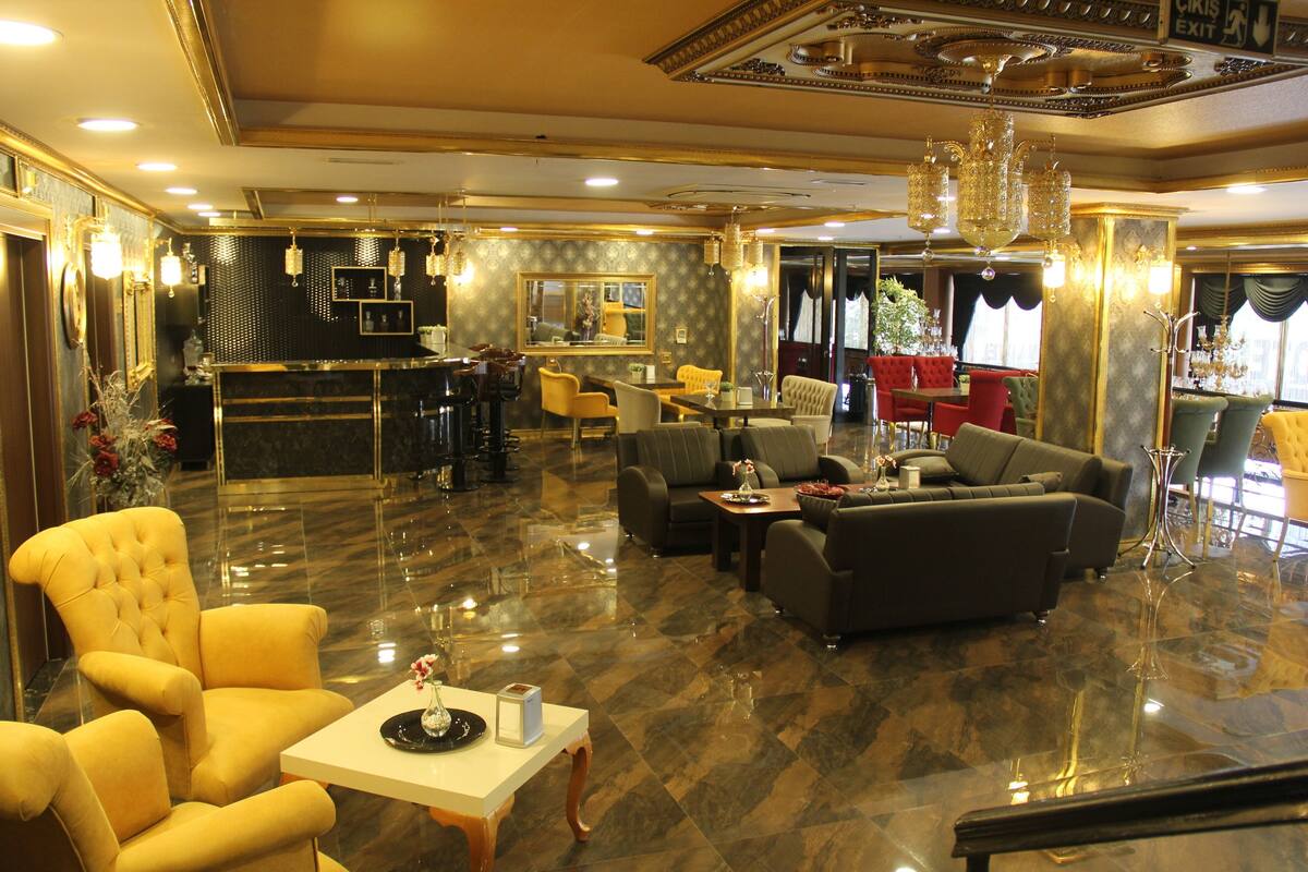 A spacious lobby with a bar area, seating arrangements, and a chandelier.