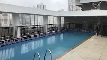 Alberca al aire libre y camastros