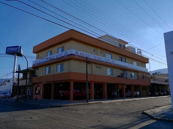 A two-story hotel with a sign reading "Hotel Maria Jose."