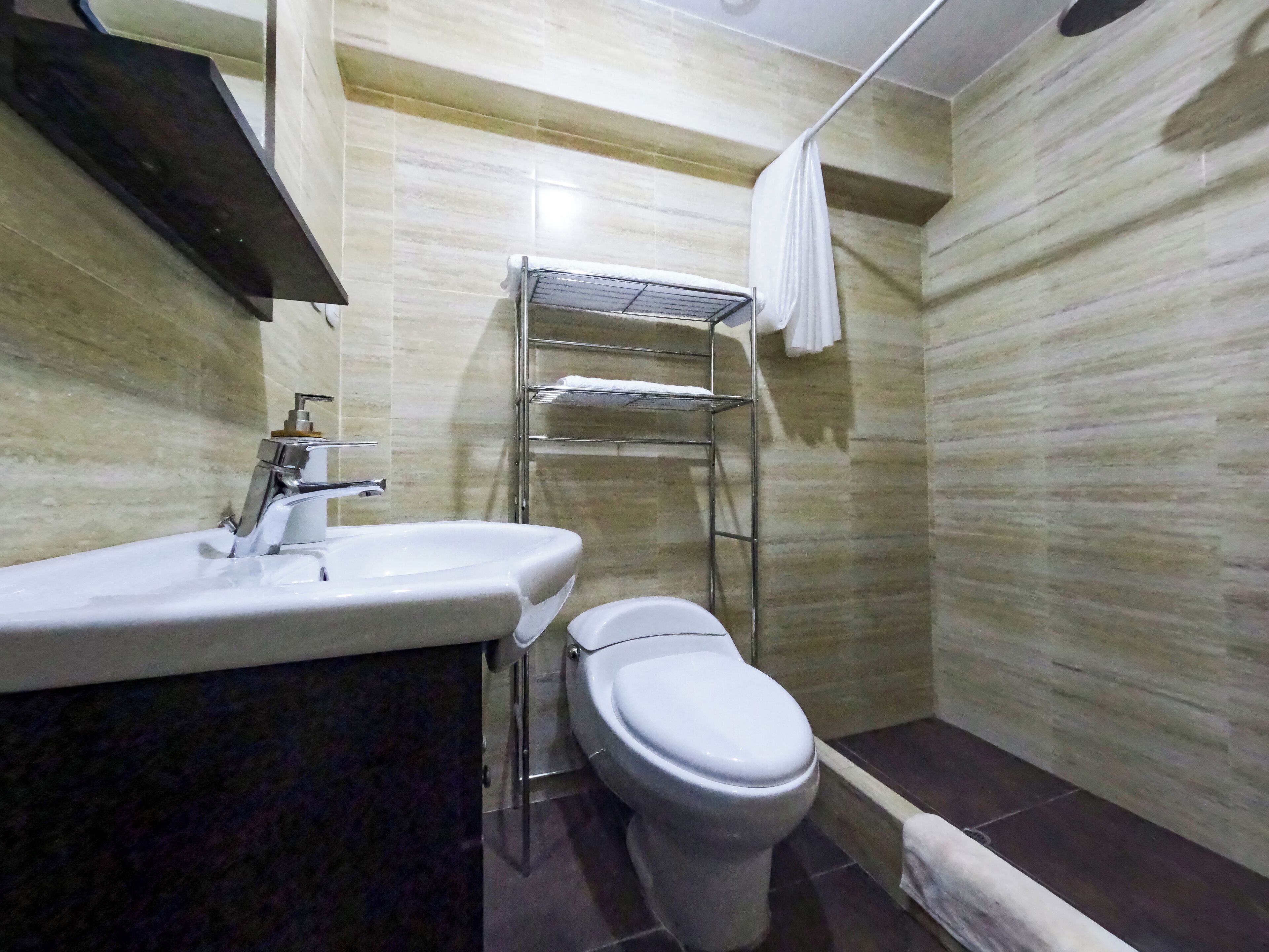 Ein Badezimmer mit Waschbecken, Toilette und Handtuchhalter.