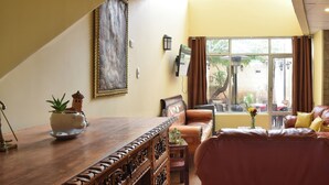 Uma sala de estar com uma mesa de centro de madeira, um sofá e uma janela grande com cortinas.