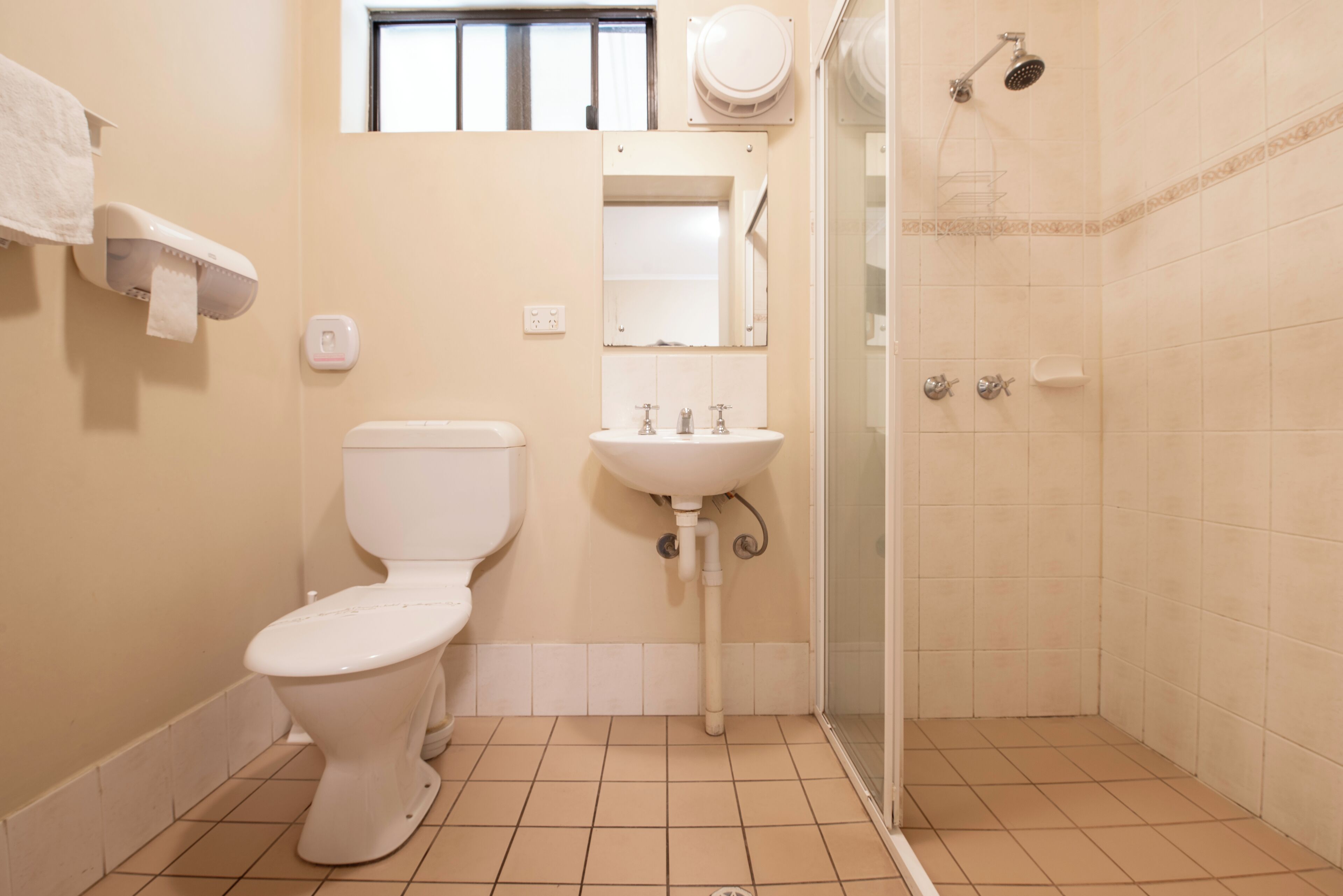 Un baño con inodoro, lavamanos y ducha.