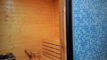 Una sauna con bancos de madera y pared de azulejos.
