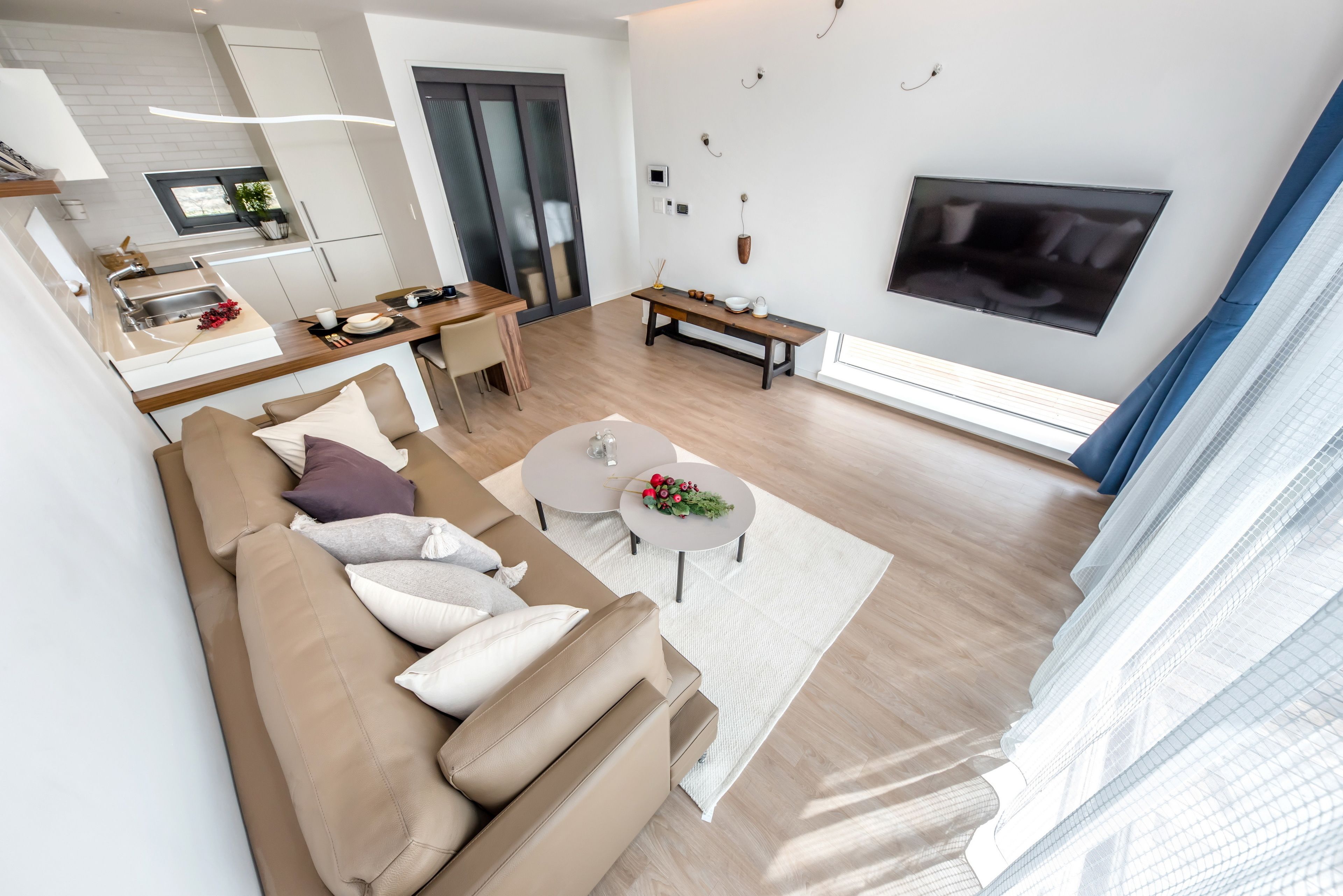 A modern living room with a sofa, coffee table, and a TV mounted on the wall.