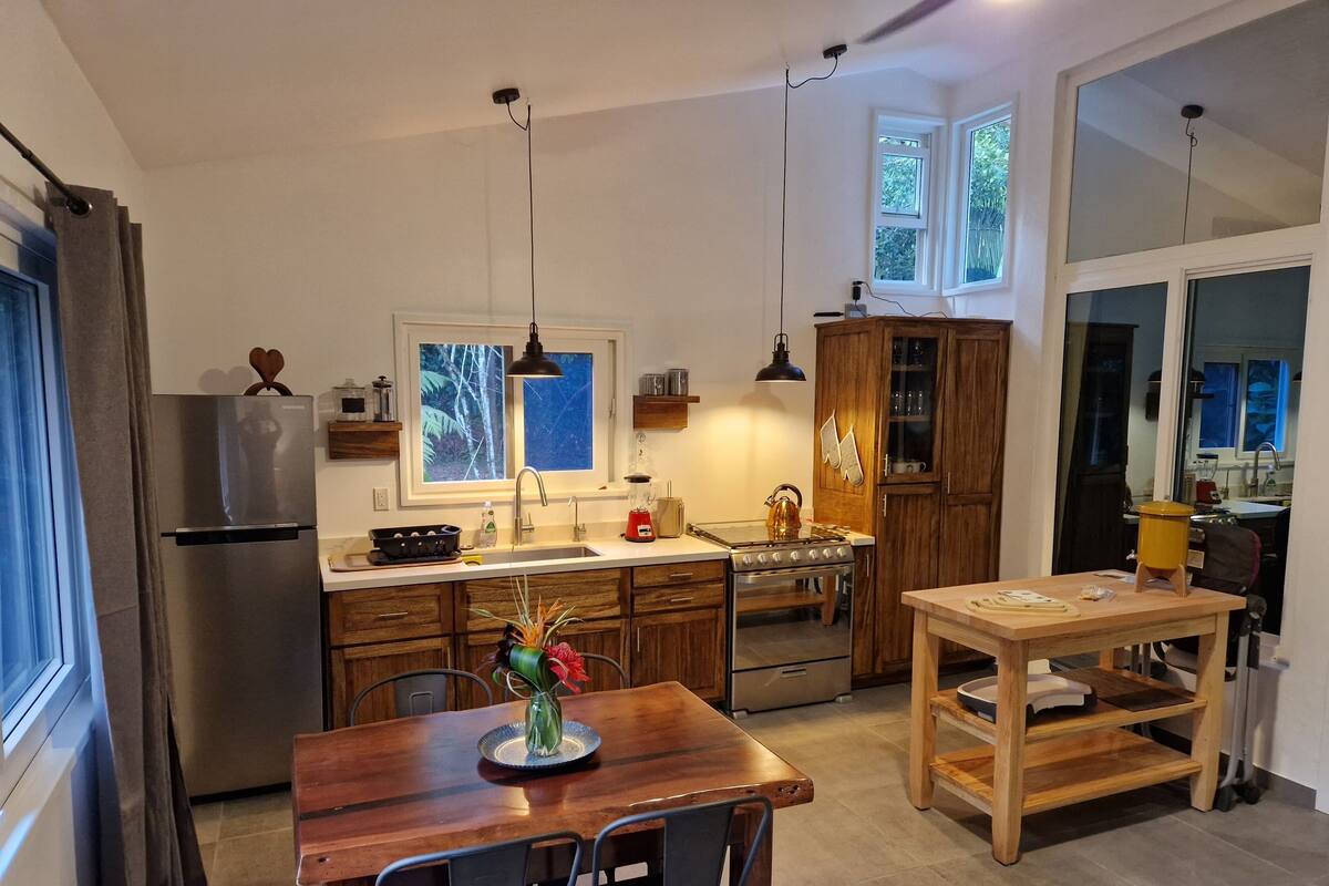 Eine moderne Küche mit einer zentralen Kochinsel, Holzschränken und einem Einbauofen.