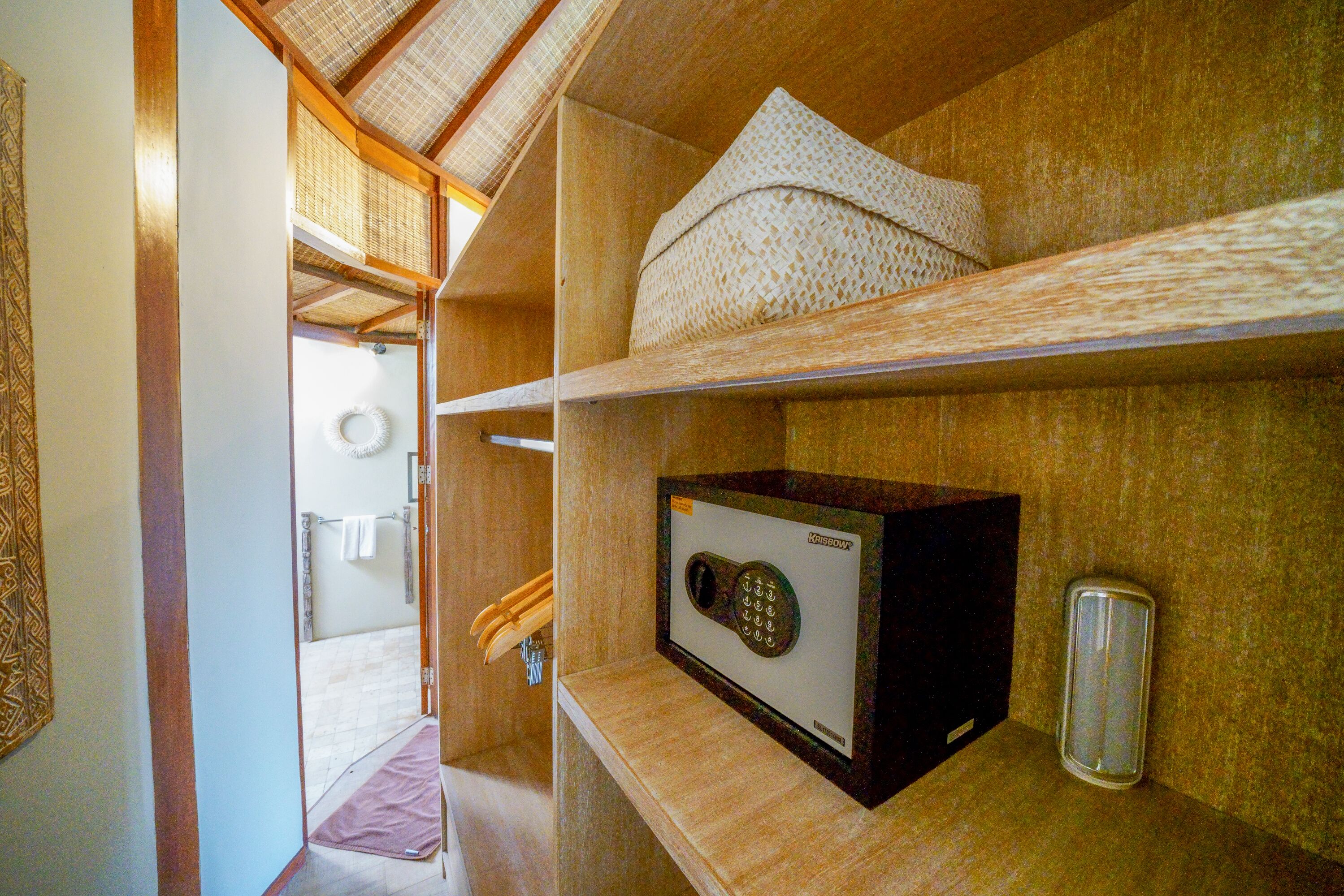 Un bagno compatto con doccia, porta asciugamani e ripiano contenente una scatola e un vassoio.