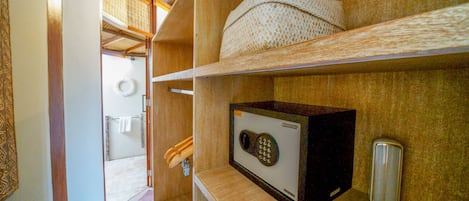 Un bagno compatto con doccia, porta asciugamani e ripiano contenente una scatola e un vassoio.