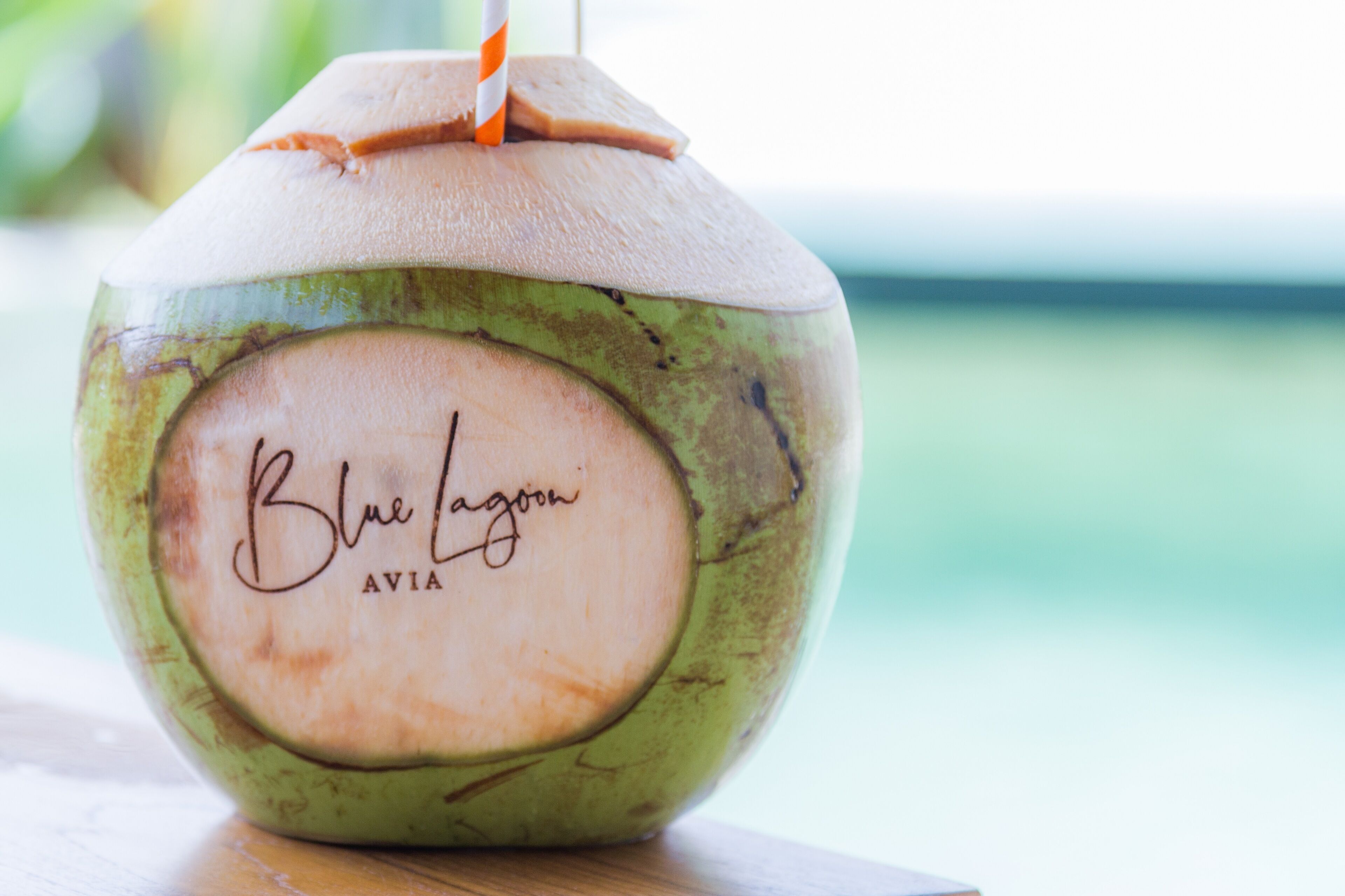 Un refresco de coco con pajita y una etiqueta que dice "Blue Lagoon AVIA".