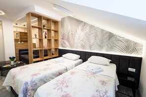 Ein Hotelzimmer mit zwei Betten, einer Holzregaleinheit und einer Wand mit einem Blattmuster.
