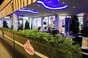 Eine Hotelhalle mit einer Rezeption, einer Sitzecke und einem Schild mit der Aufschrift 'Lotos'.