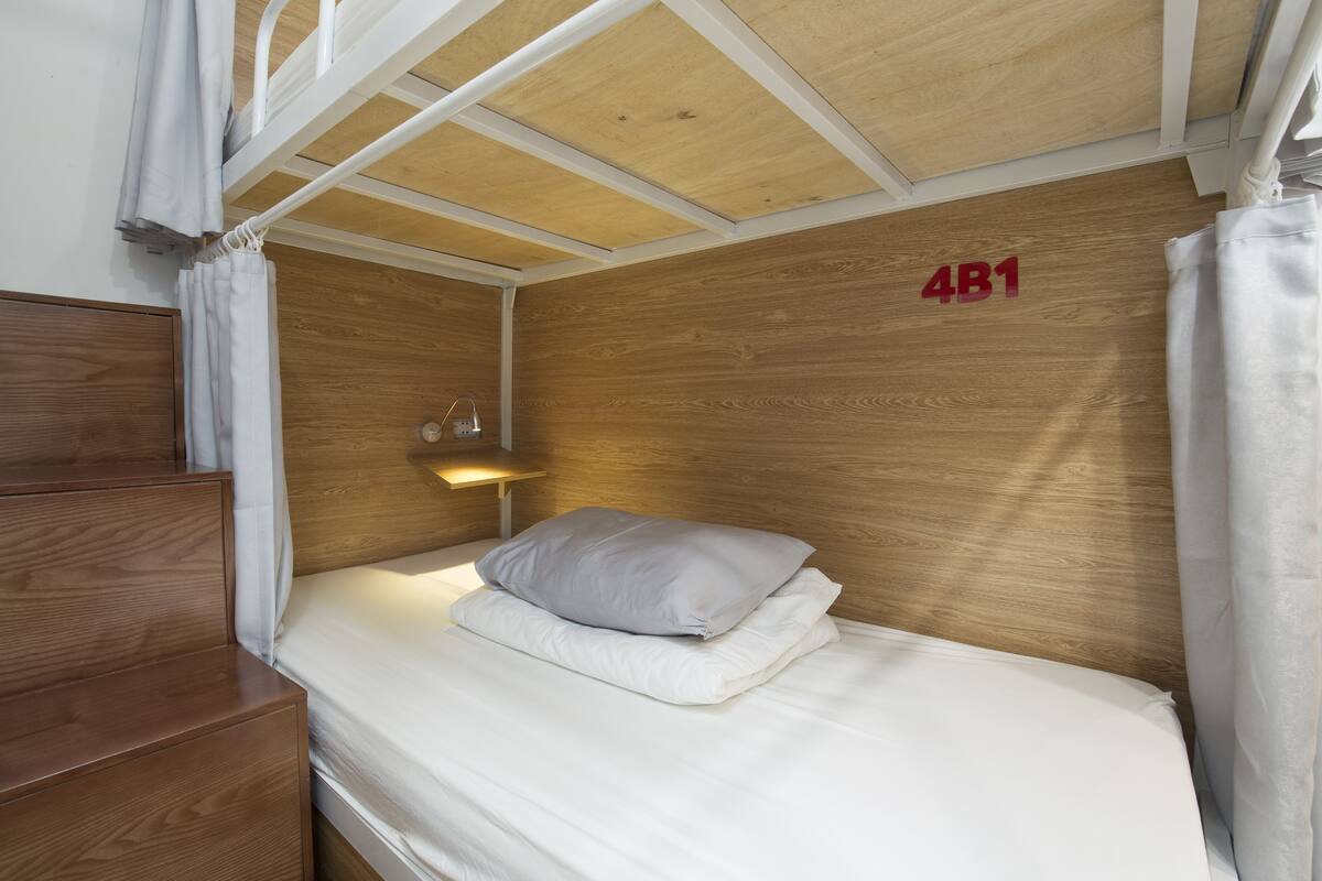A single bed with a headboard, a bedside table, and a nightstand.